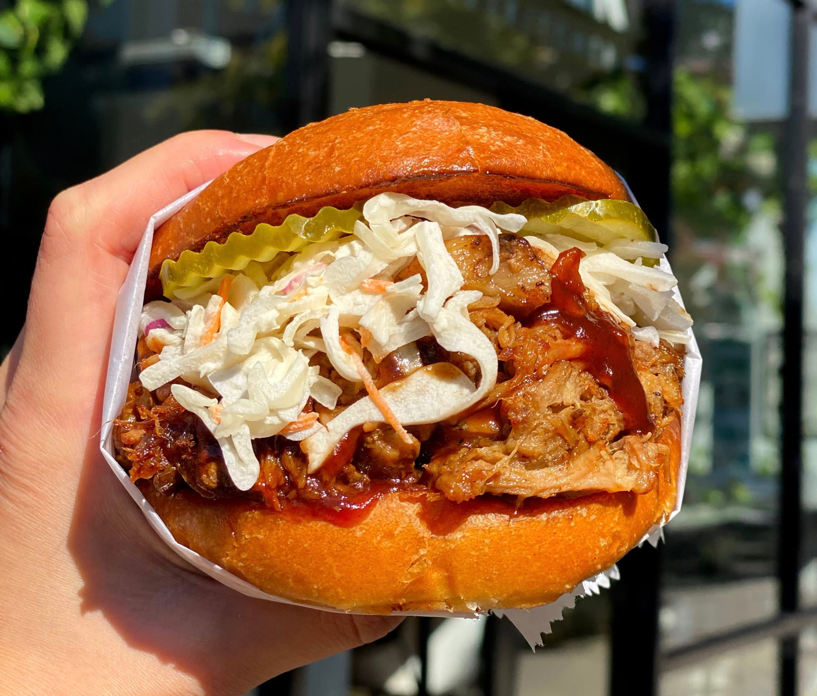 BBQ Pulled Pork sandwich with coleslaw and pickles on a griddled bun