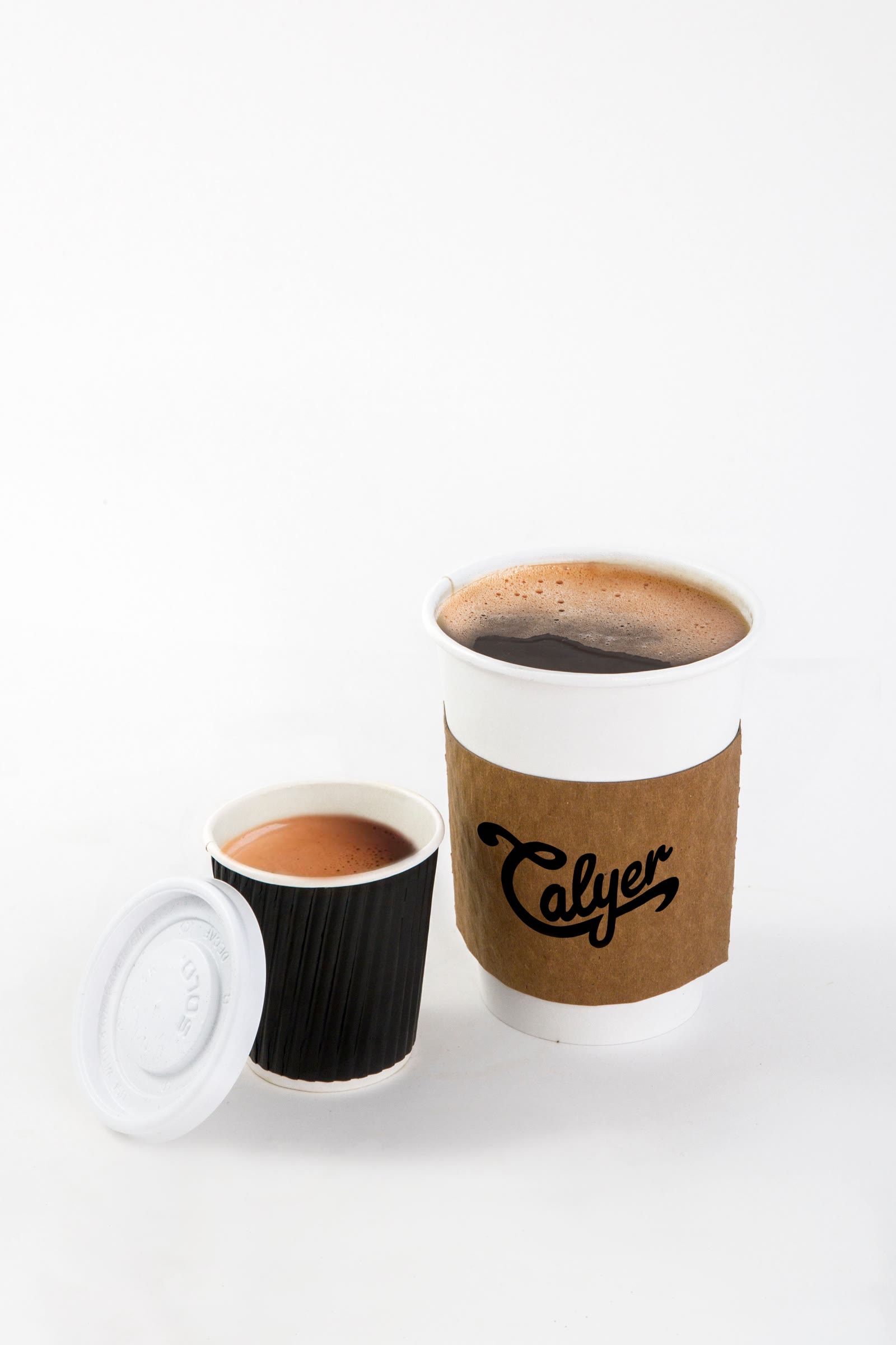 Calyer drip coffee in a kraft-sleeved cup next to an espresso